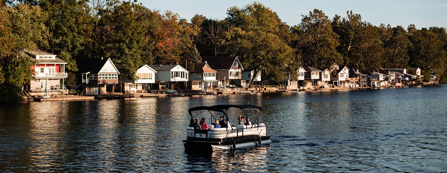 A boat, navigating the Lehigh River, in front of River House at The Waterfront in Allentown, Pennsylvania.