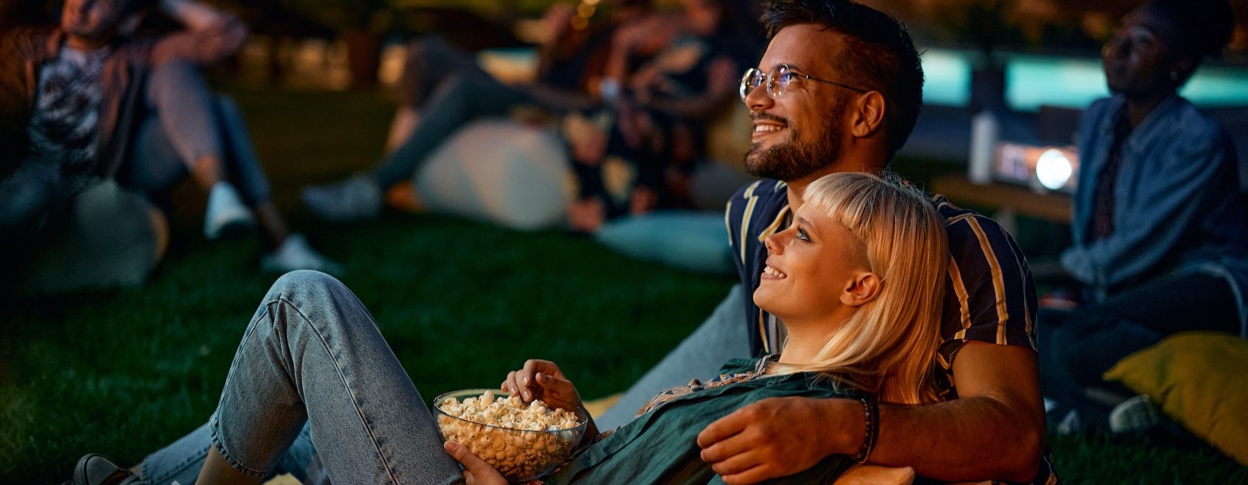 a couple enjoying a movie in a park